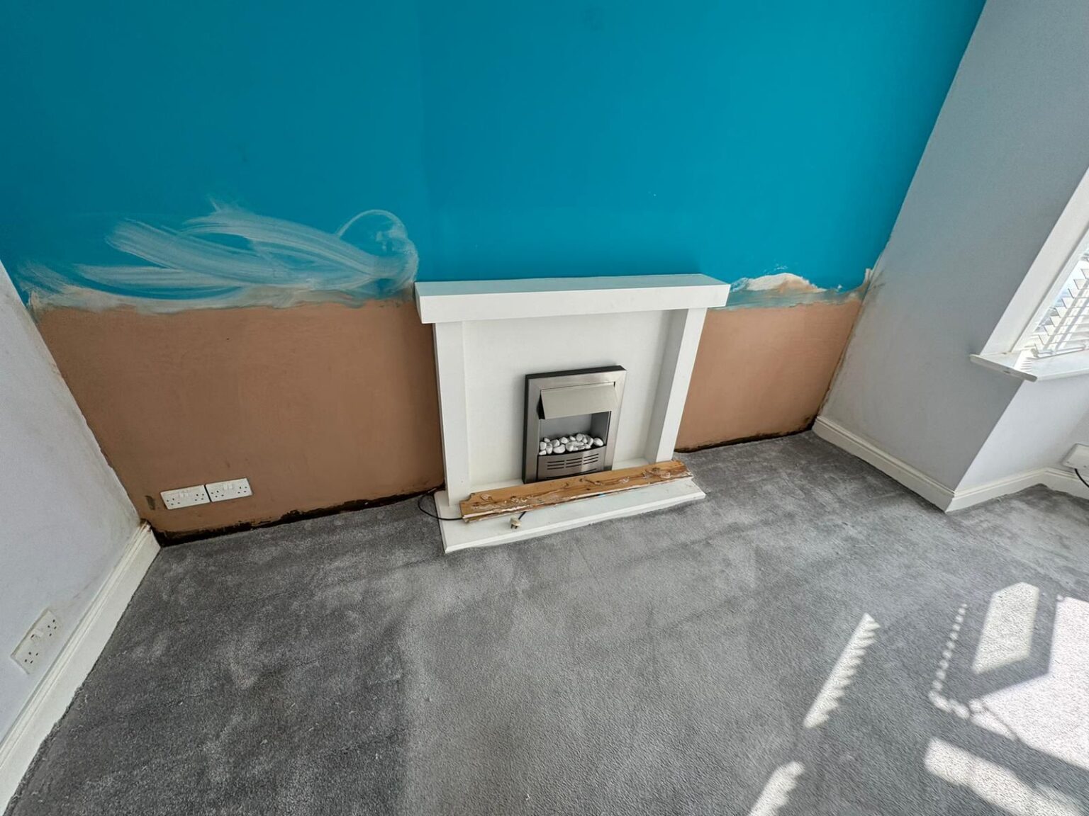 Replastered wall after rising damp treatment — salt-resistant render applied, ready to paint